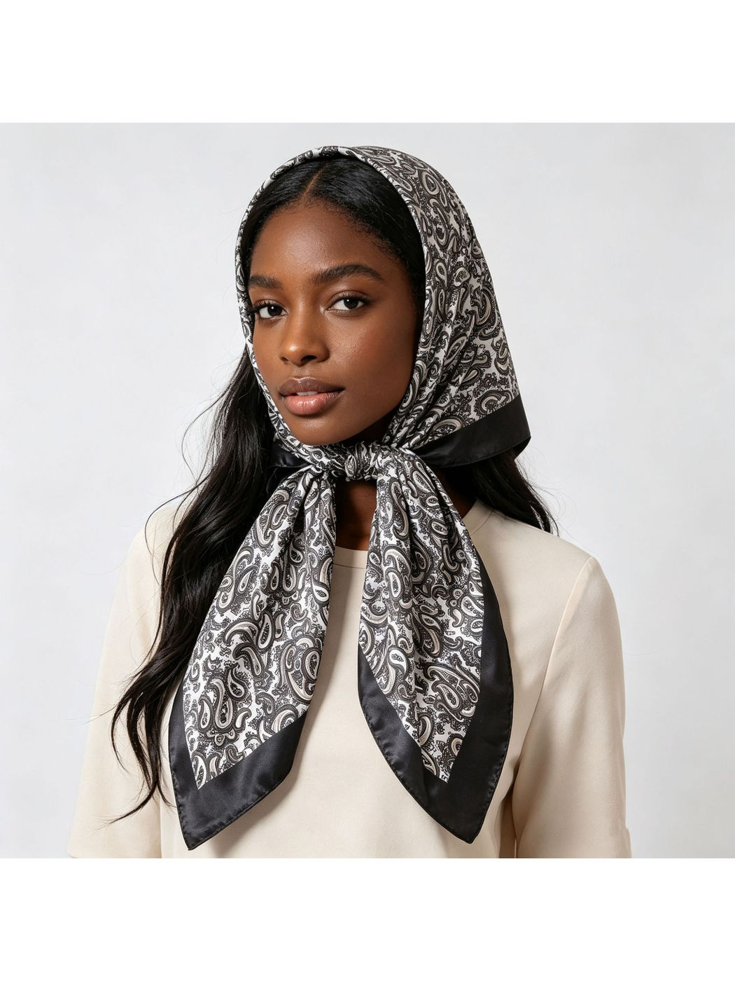 Black and white paisley scarf wrapped over the head and tied under the chin