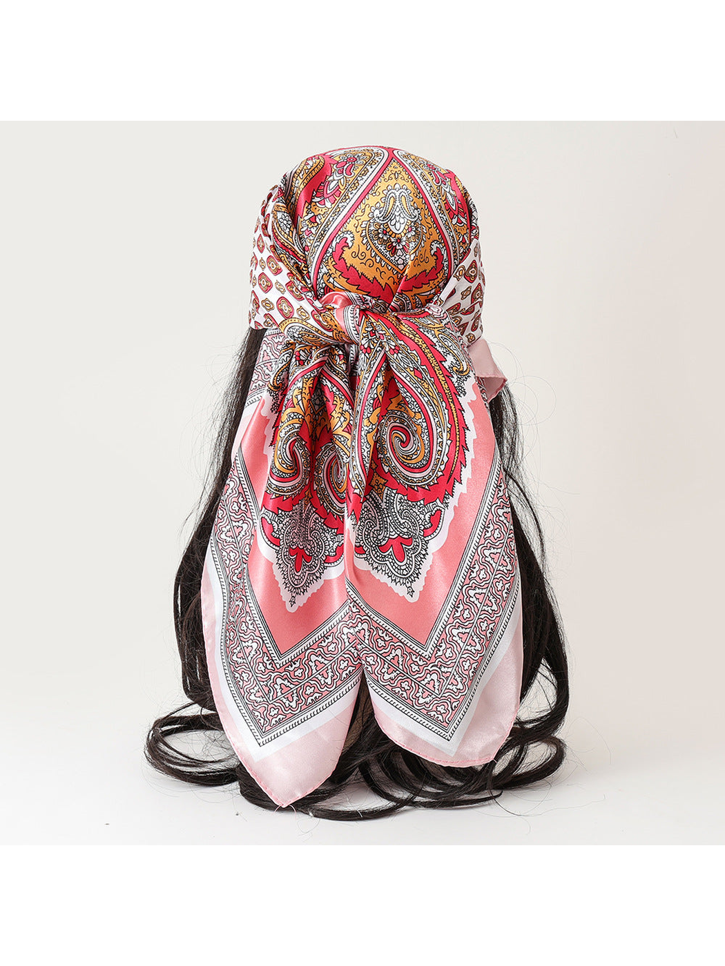 Pink paisley square scarf tied over a dark-haired mannequin, back view