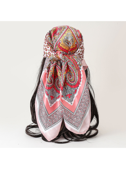 Pink paisley square scarf tied over a dark-haired mannequin, back view