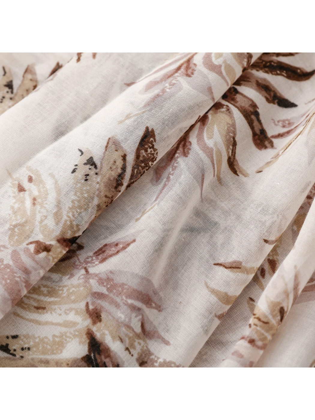 Close-up of the lightweight botanical-print scarf draped in soft folds
