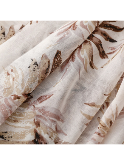 Close-up of the lightweight botanical-print scarf draped in soft folds