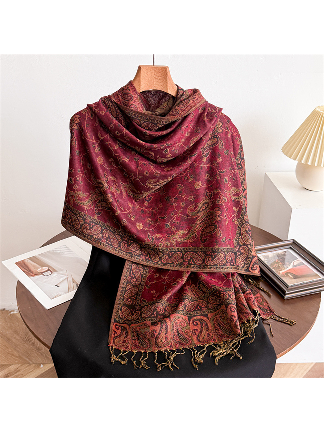 Burgundy paisley scarf draped on a display form with fringed ends