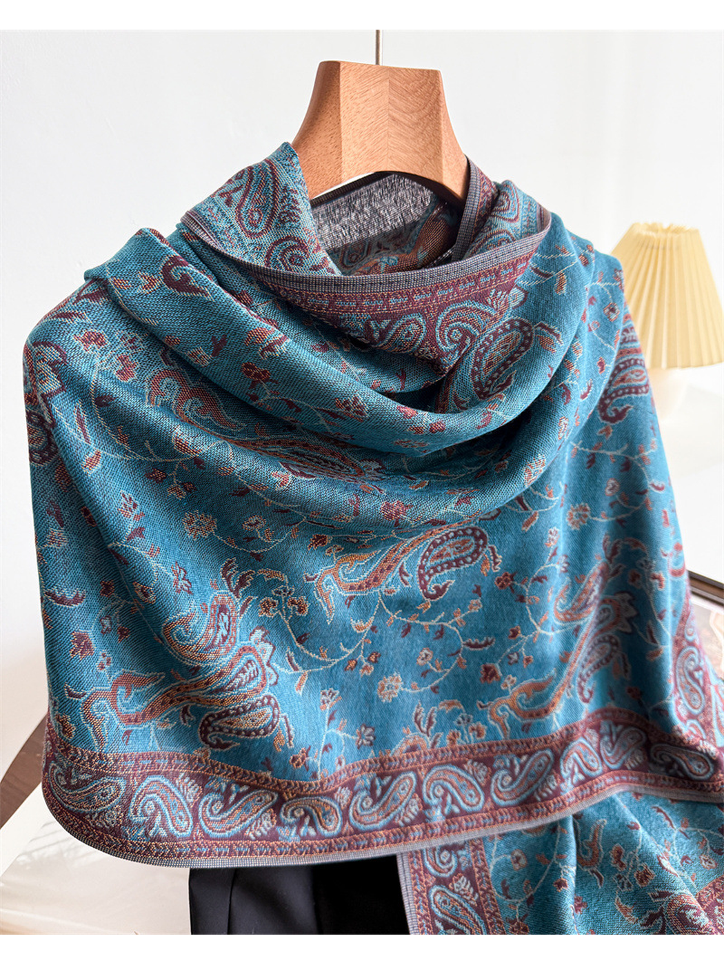 Close-up of the lake blue scarf's layered drape and paisley border