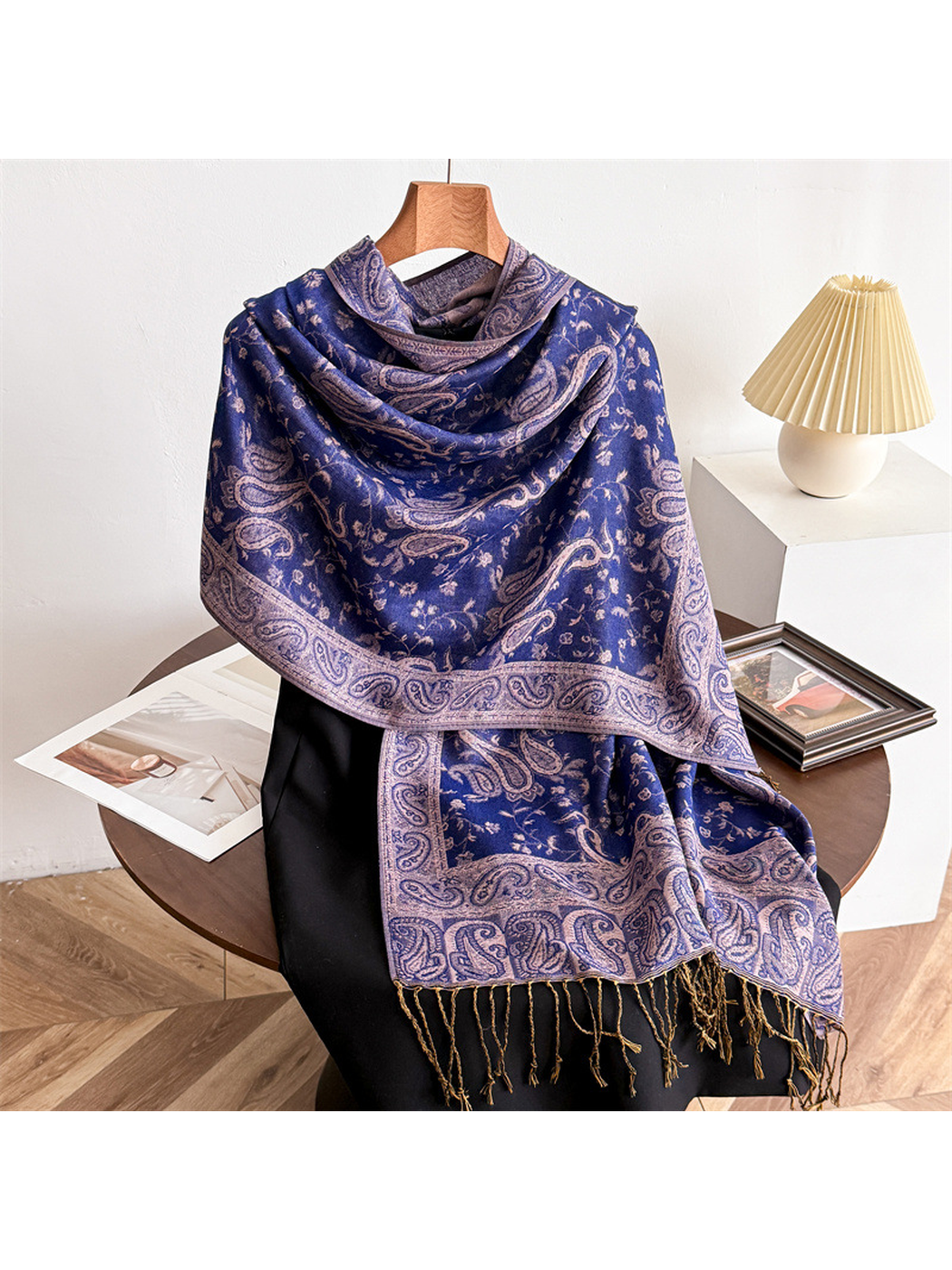 Navy paisley scarf draped on a display form with fringed ends