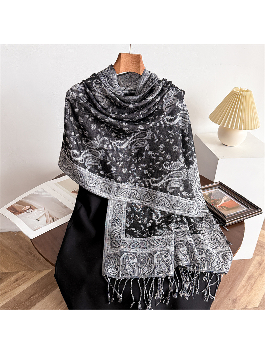Black and gray paisley scarf draped on a display form with fringed ends