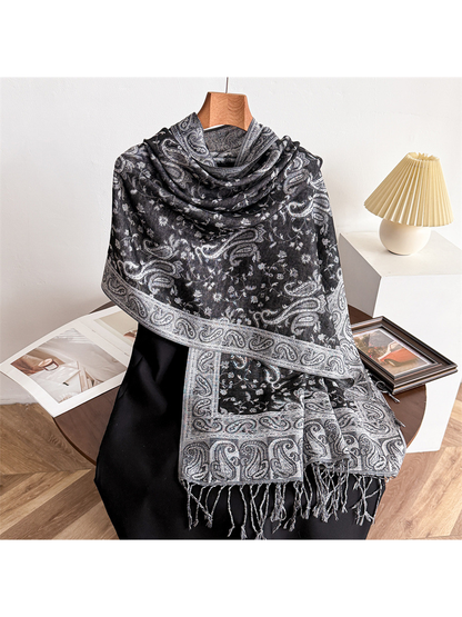 Black and gray paisley scarf draped on a display form with fringed ends