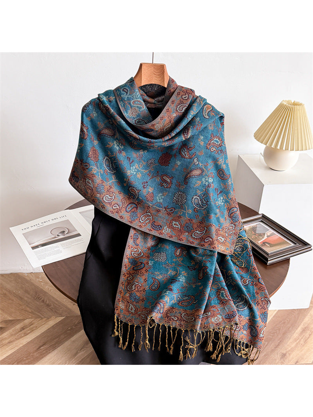 Lake blue paisley scarf draped to show the contrasting border and twisted fringe