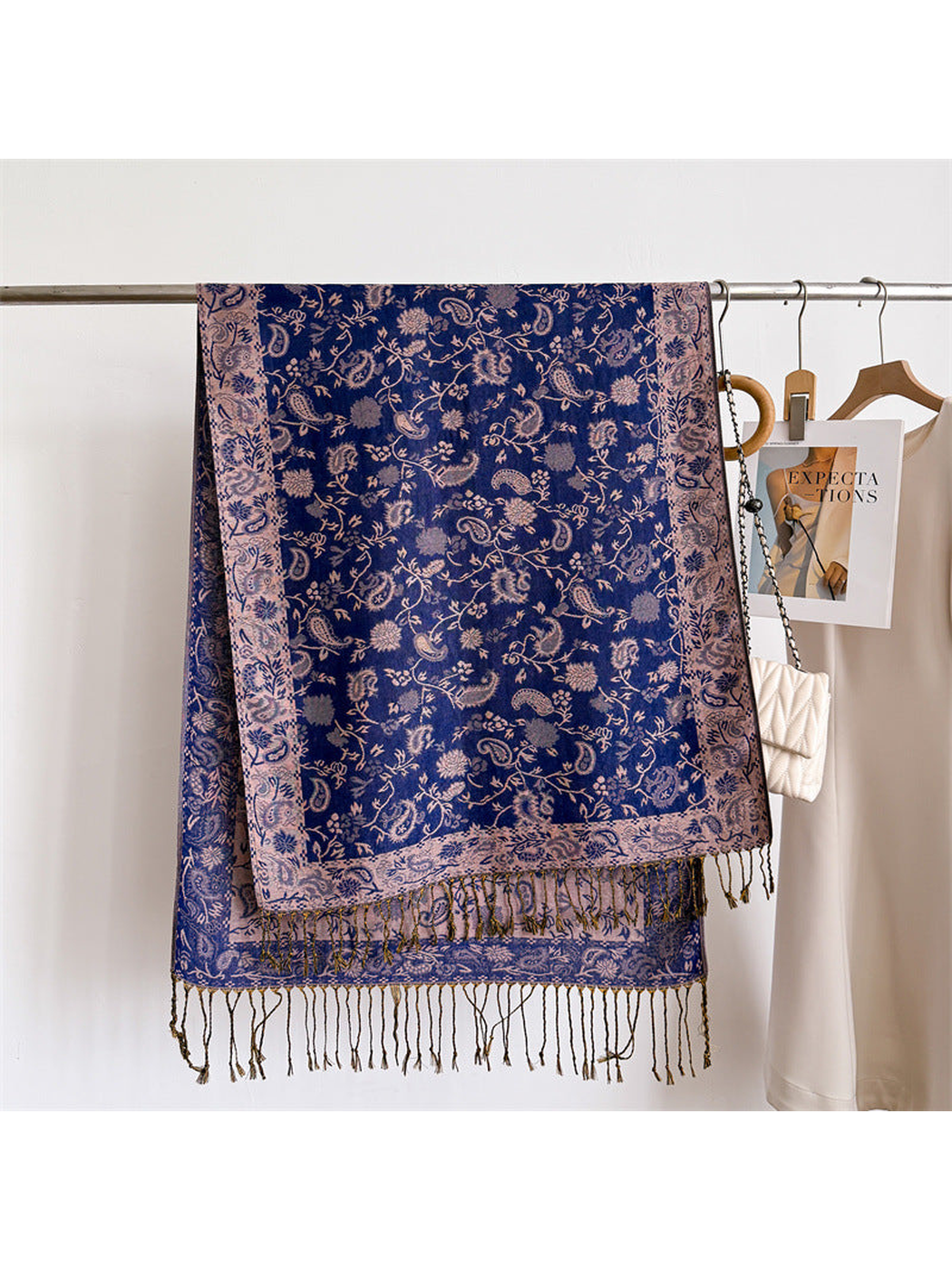 Royal blue paisley scarf displayed flat with a pale ornamental border and fringe