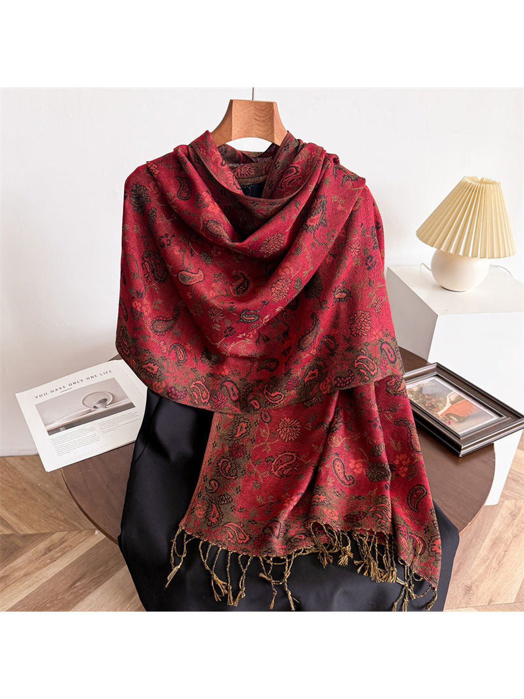 Red paisley scarf draped to show the dark motifs and twisted fringe