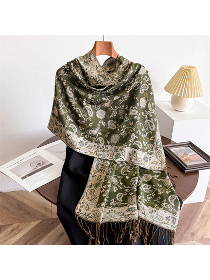 Olive green paisley scarf draped with a cream ornamental border and fringe