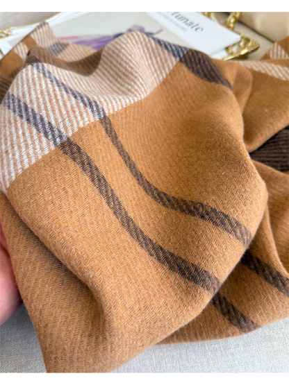 Close-up of the fine herringbone texture and camel plaid pattern