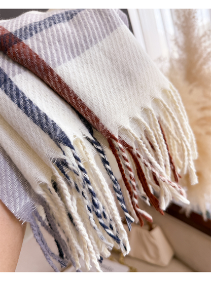 Close-up of twisted fringe continuing the ivory scarf's plaid colors