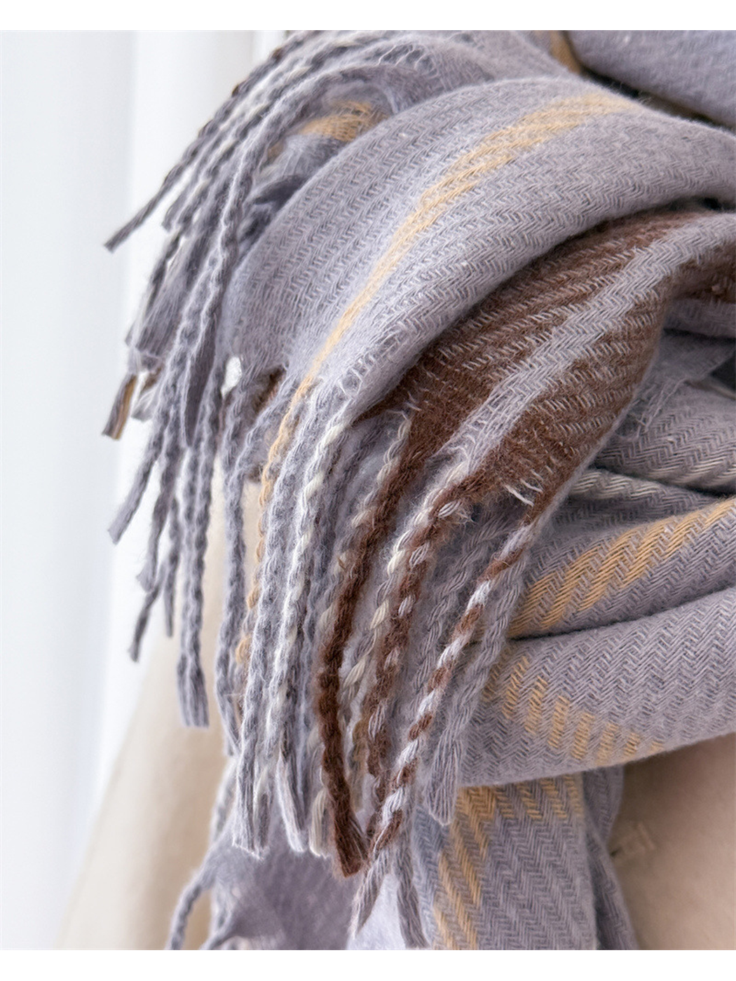 Close-up of gray plaid scarf fringe and herringbone texture