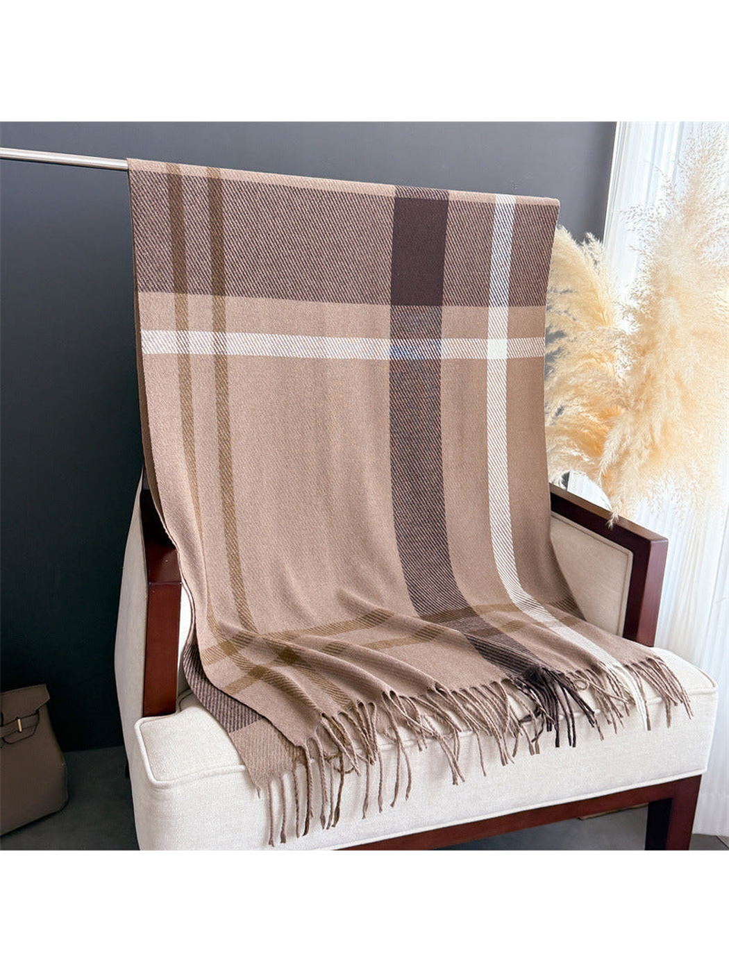 Brown plaid rectangular scarf with fringe draped over a chair