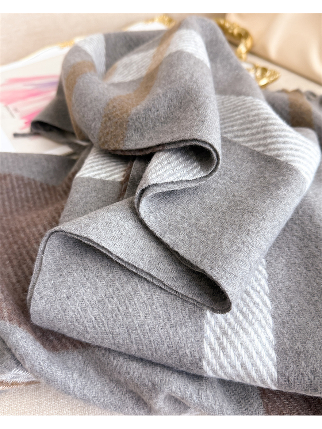 Close-up of folded gray plaid scarf edges and herringbone texture