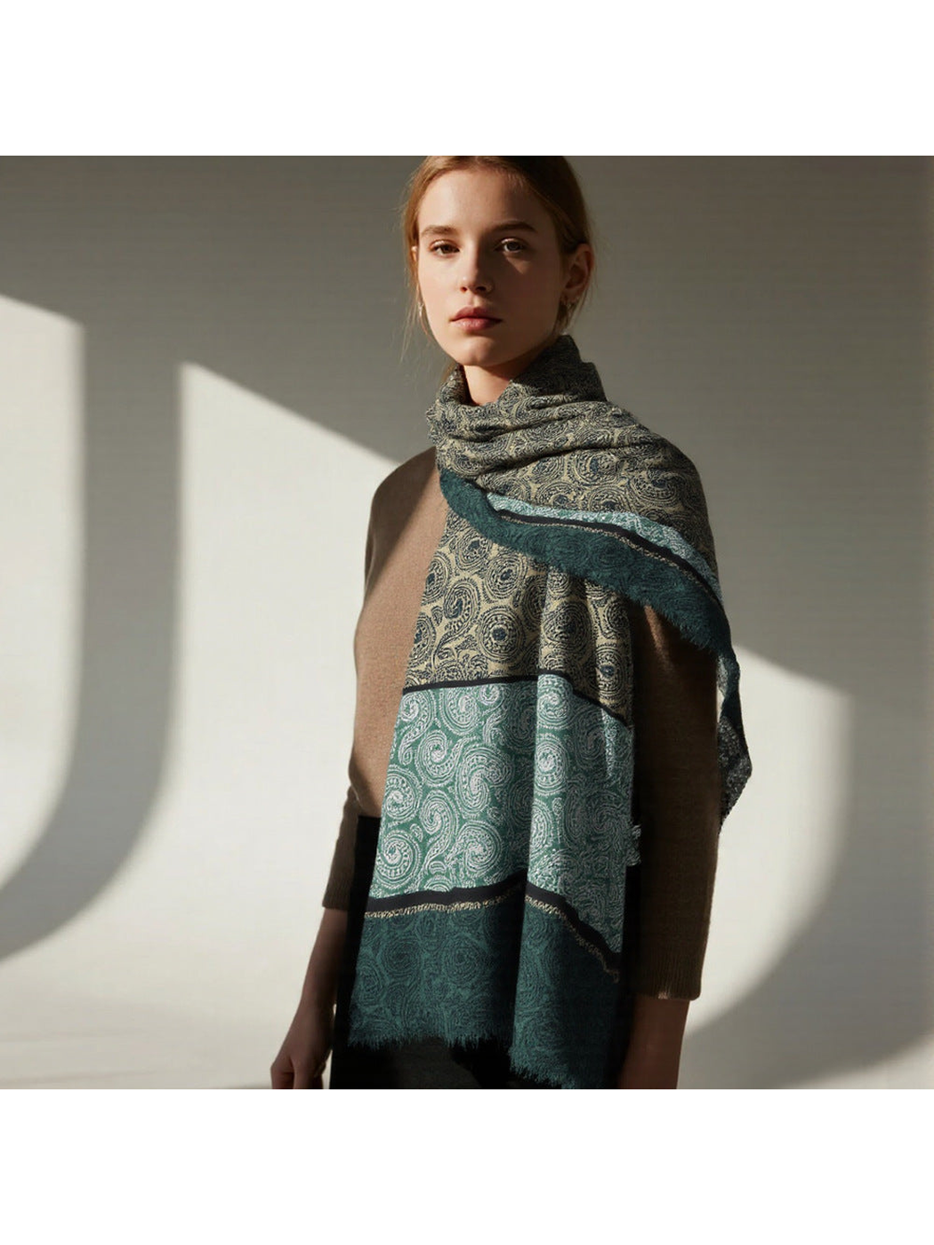 Green paisley scarf looped around the neck with both ends hanging in front