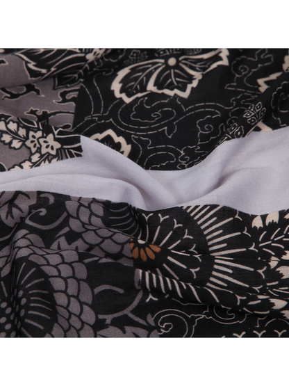 Close-up of the black and gray scarf's floral patchwork and contrasting pale panel