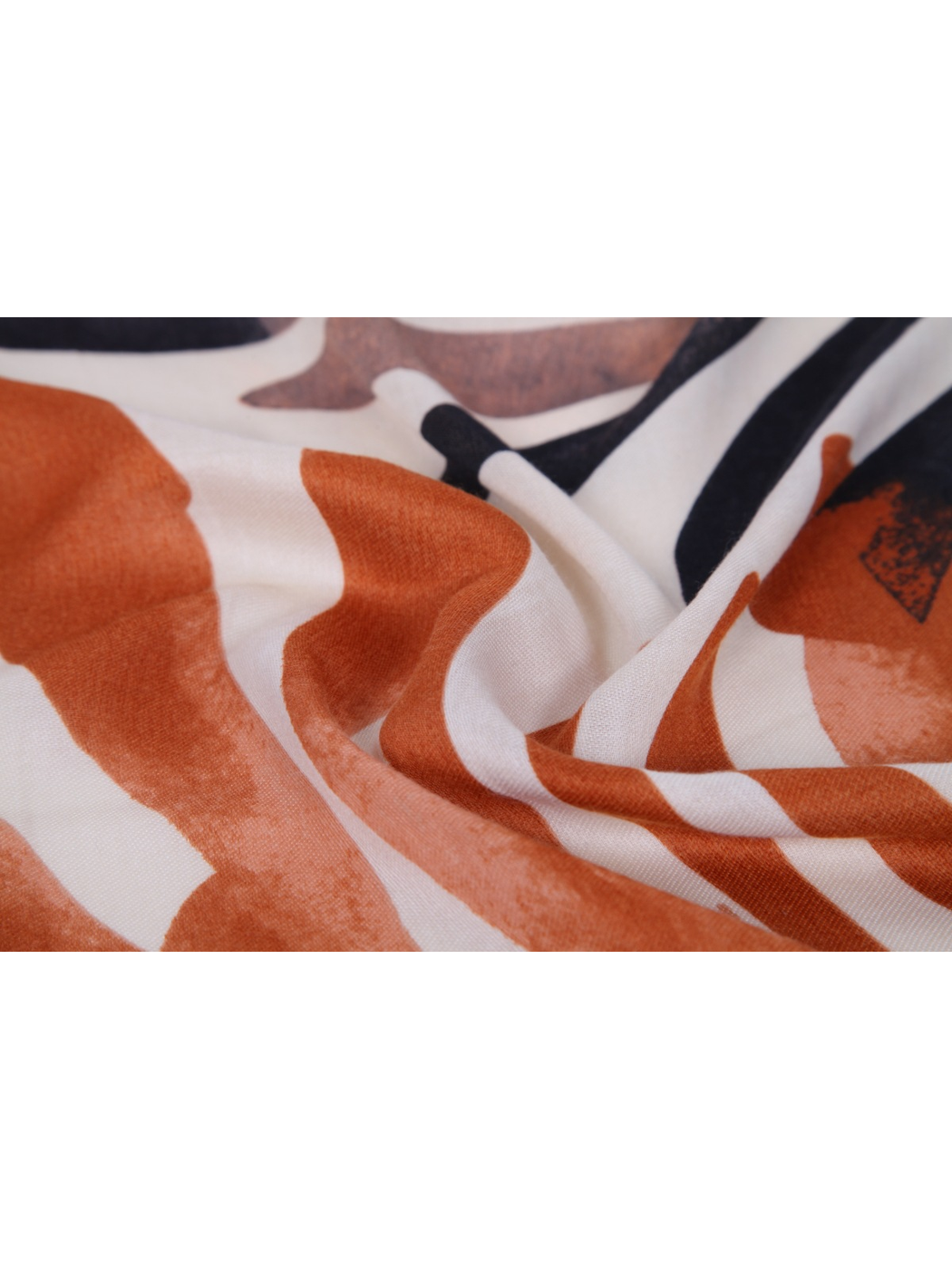 Close-up of the orange, ivory and black print with fine woven texture