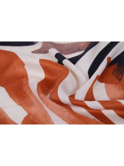 Close-up of the orange, ivory and black print with fine woven texture