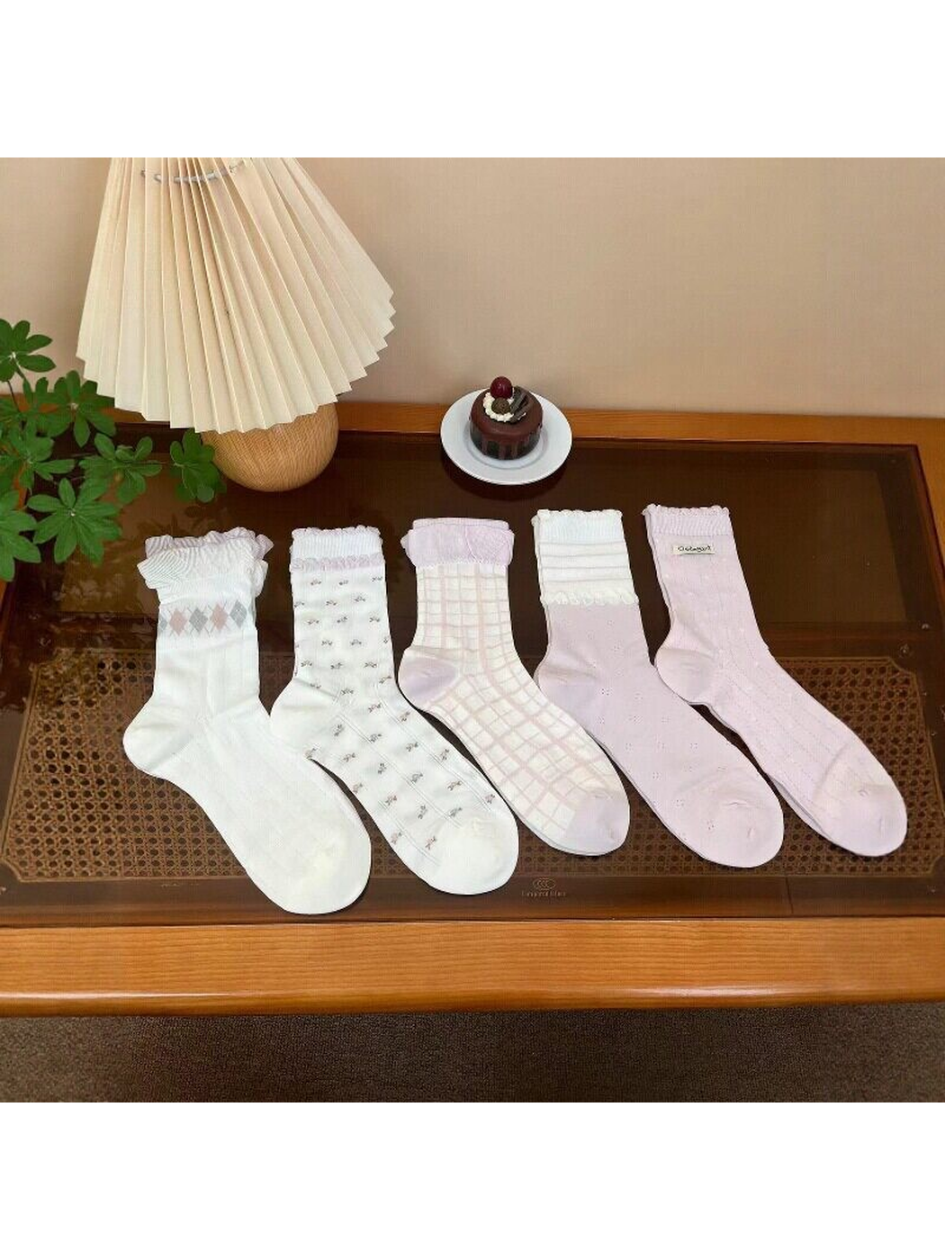 Five ivory and light pink sock designs displayed together