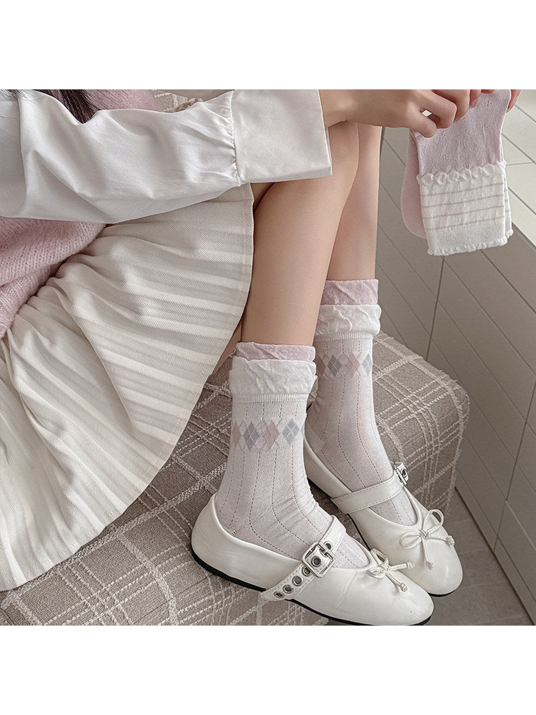 Ivory argyle and light pink striped socks styled with white Mary Jane shoes