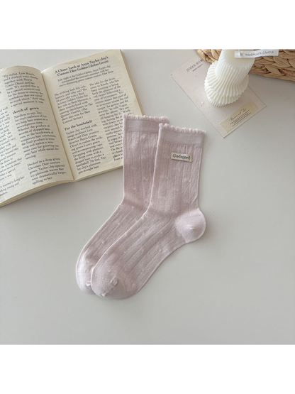 Light pink pointelle socks with ruffled cuffs and small label