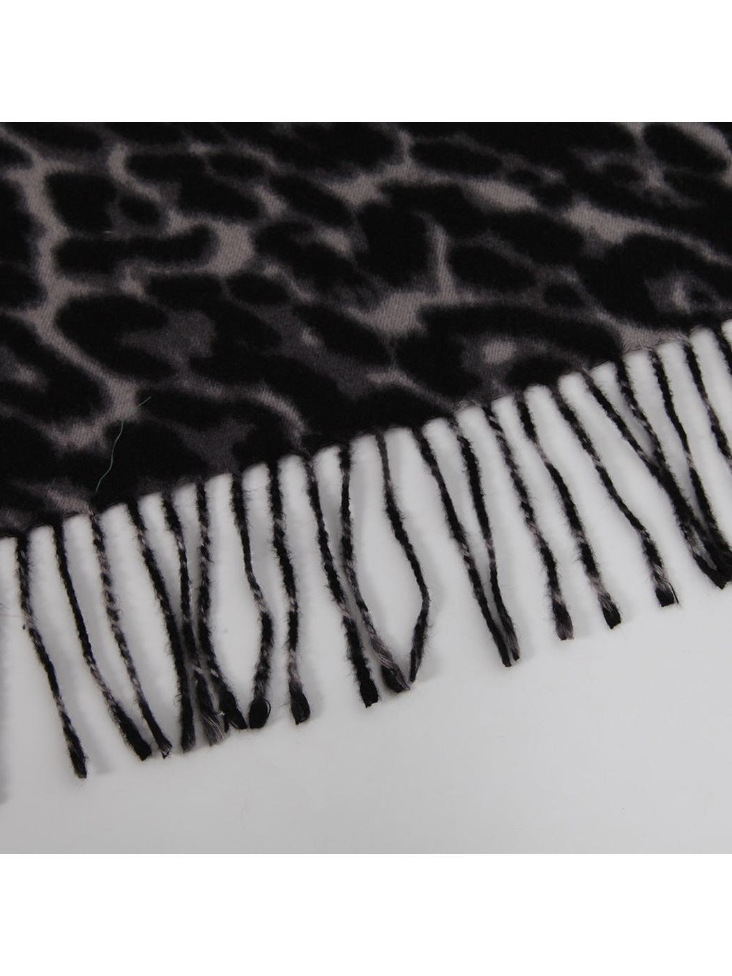 Close-up of the black and gray leopard-print scarf edge with twisted fringe