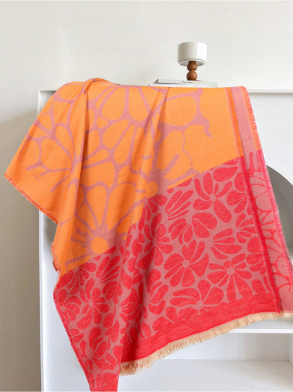 Orange and red floral scarf draped to show its contrasting large and small flower panels