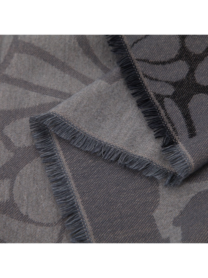 Close-up of the gray floral scarf's short fringed edges and contrasting reverse