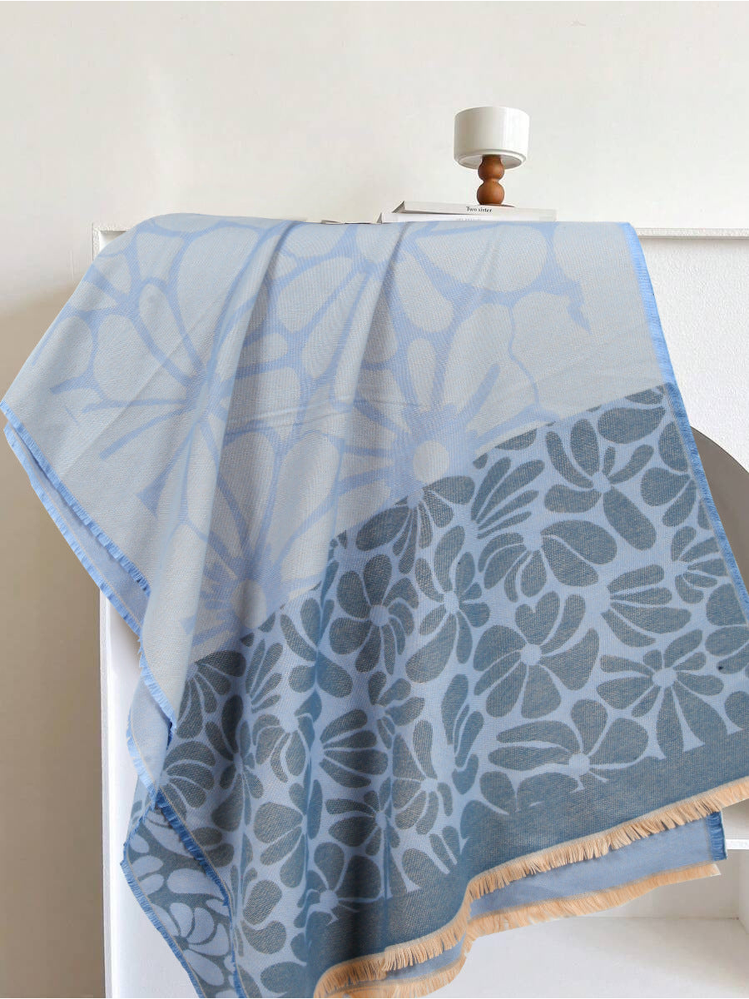 Light blue and slate floral scarf draped to show its contrasting flower panels and fringe