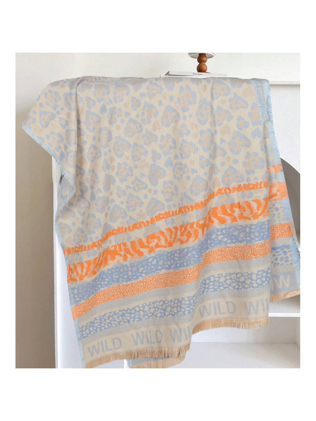 Light blue rectangular scarf with orange patterned bands and fringed edges