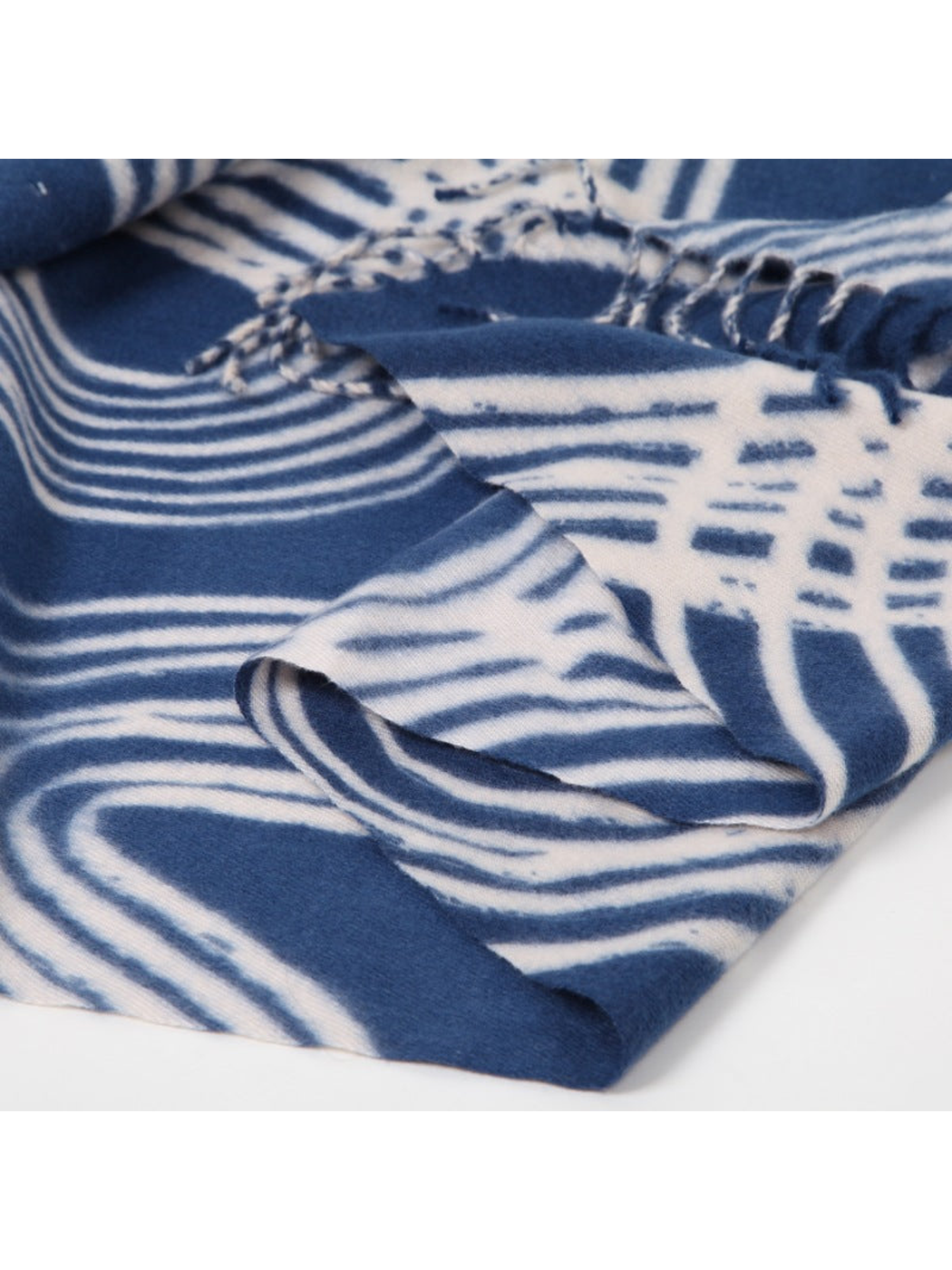 Close-up of the blue scarf's brushed texture and abstract line pattern
