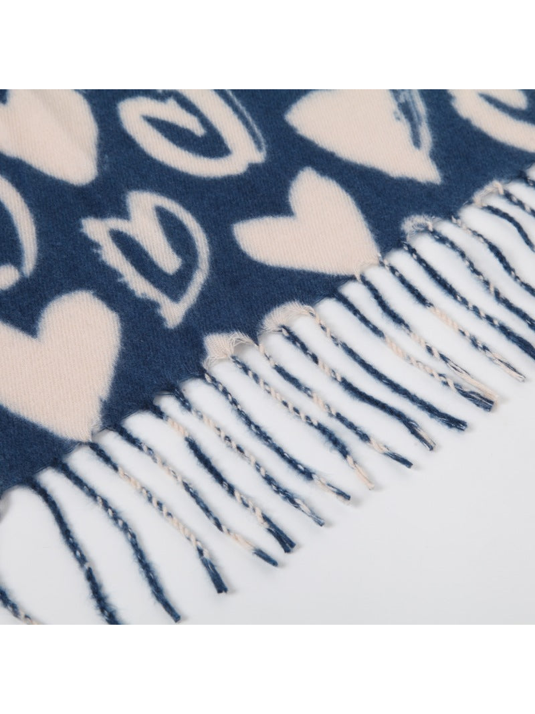 Close-up of the navy heart-pattern scarf edge and twisted fringe