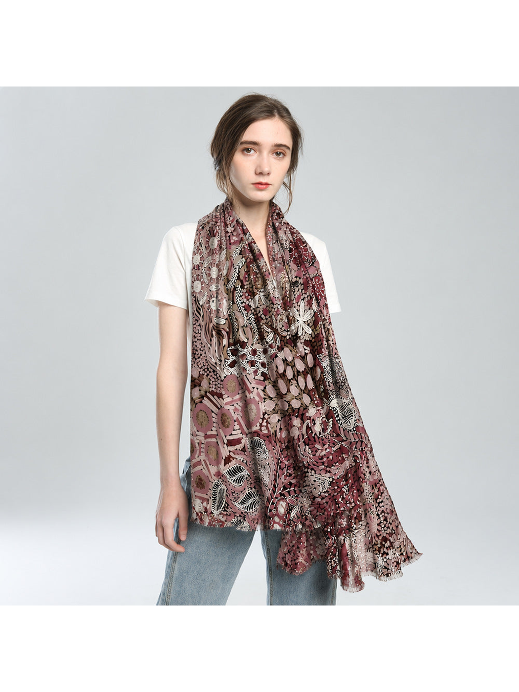 Rose-toned abstract botanical scarf draped loosely over a white top