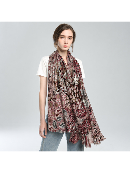 Rose-toned abstract botanical scarf draped loosely over a white top