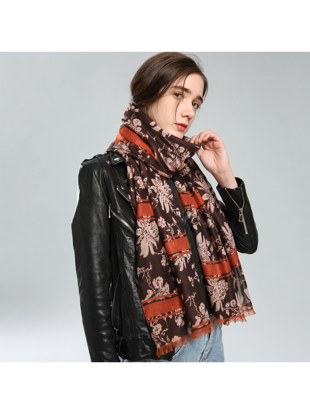 Brown and rust patterned scarf wrapped around the neck with both ends hanging in front
