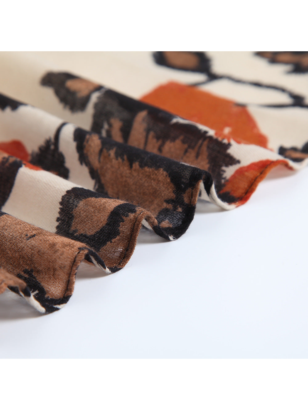 Close-up of the botanical scarf arranged in overlapping semi-sheer folds