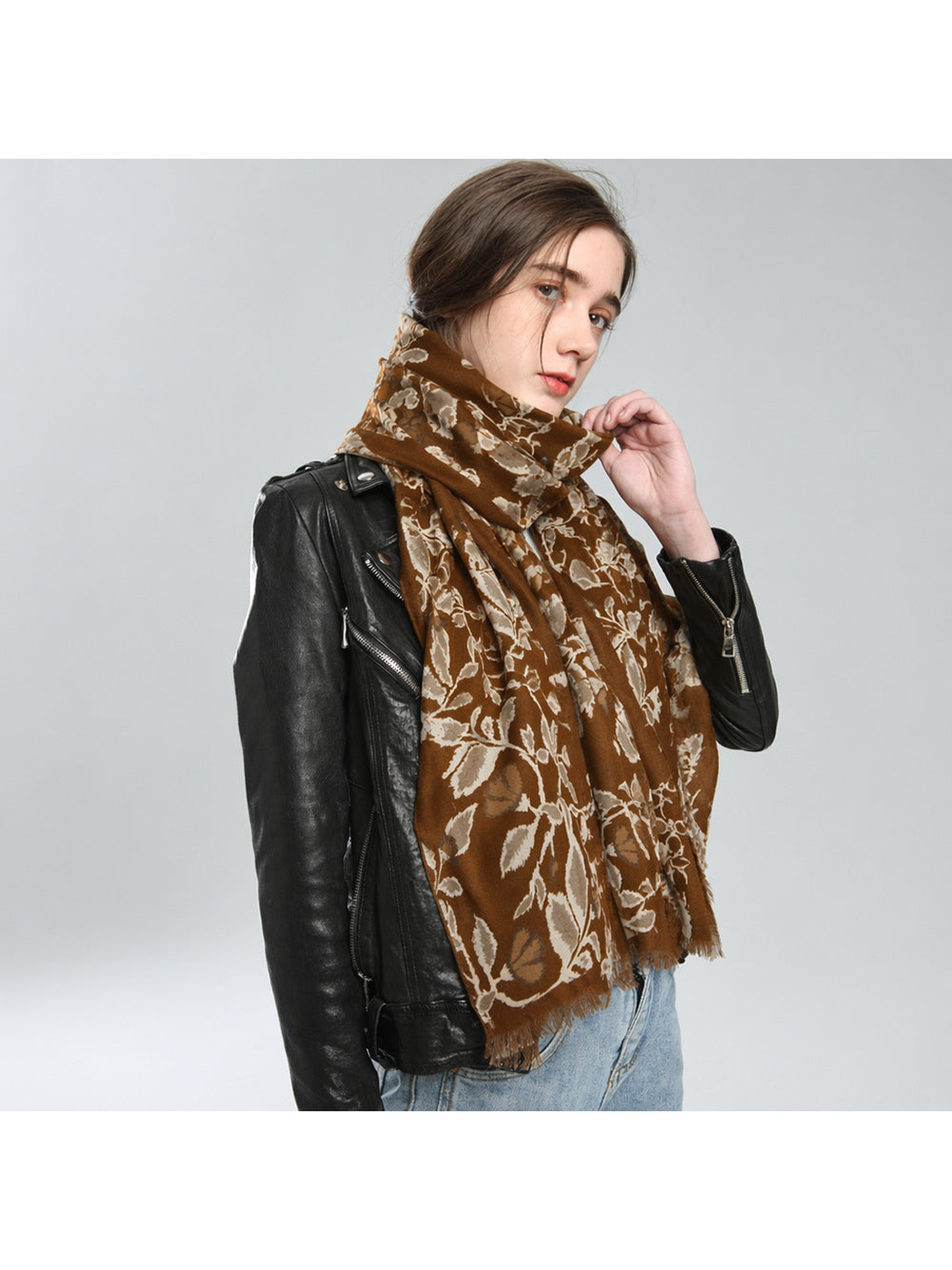 Brown botanical scarf wrapped around the neck with broad ends hanging in front