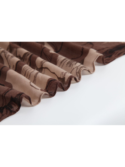 Close-up of the brown floral scarf's fine weave and narrow stitched edge