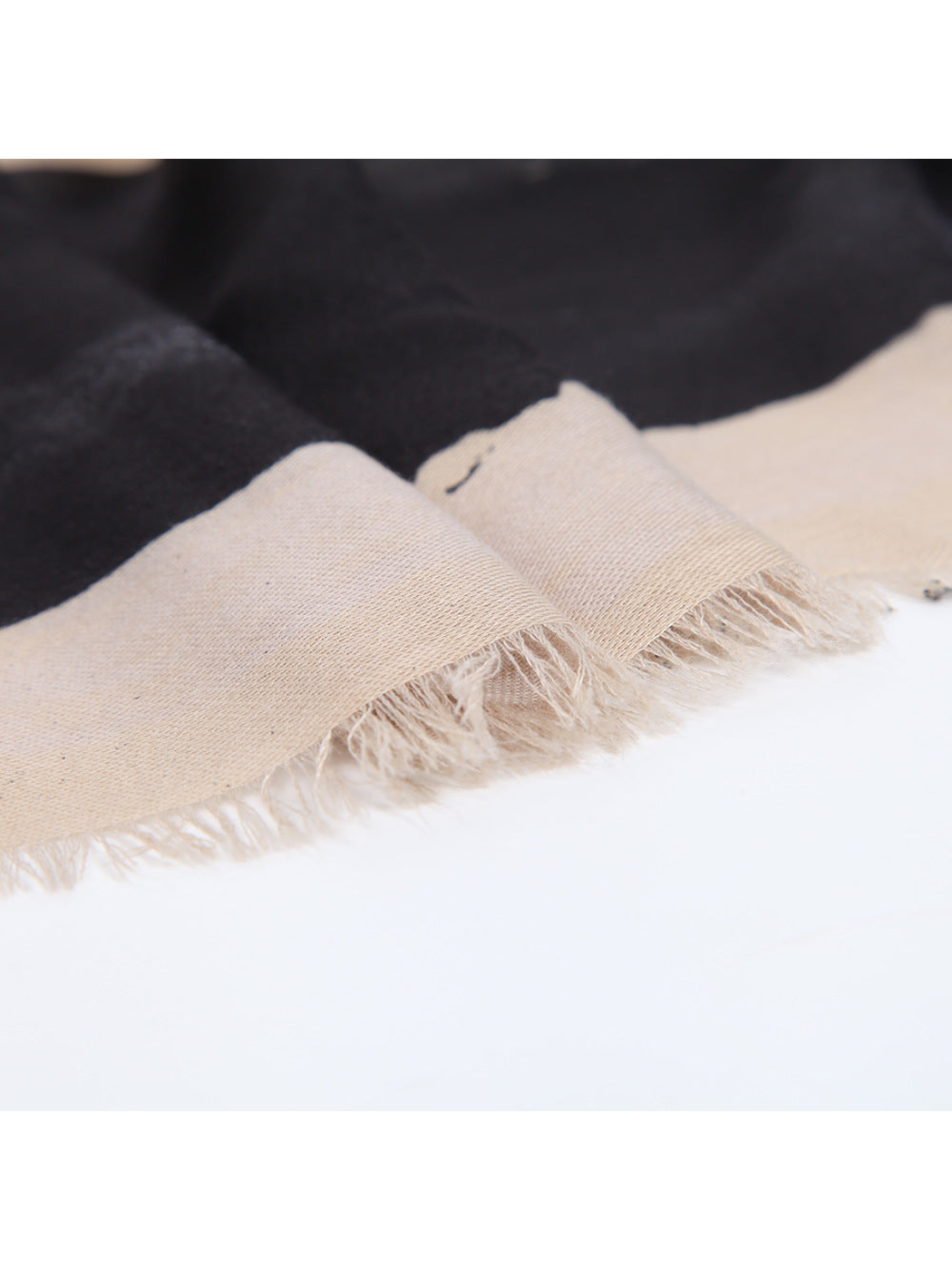 Close-up of the scarf's cream fringed edge and fine weave
