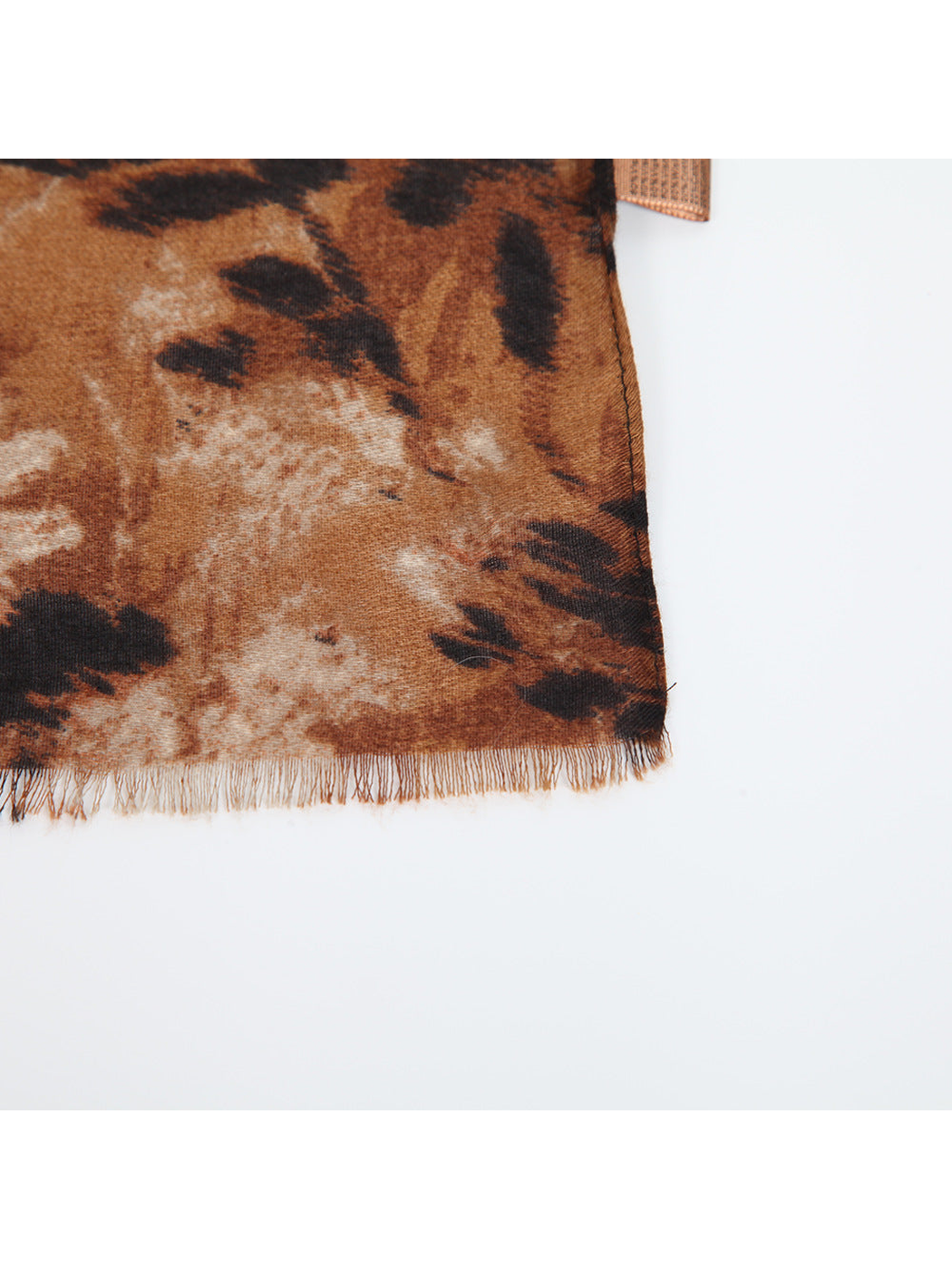 Close-up of the floral scarf's short fringe, woven texture and stitched edge