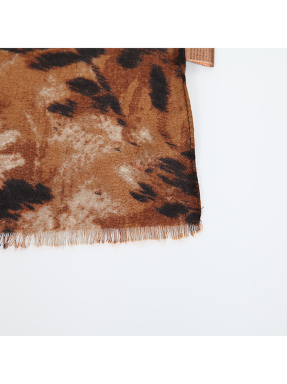 Close-up of the floral scarf's short fringe, woven texture and stitched edge