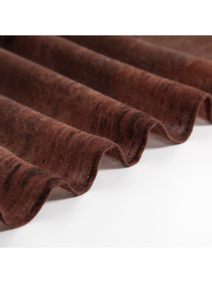 Close-up of the rust scarf's fine woven texture and lightweight drape