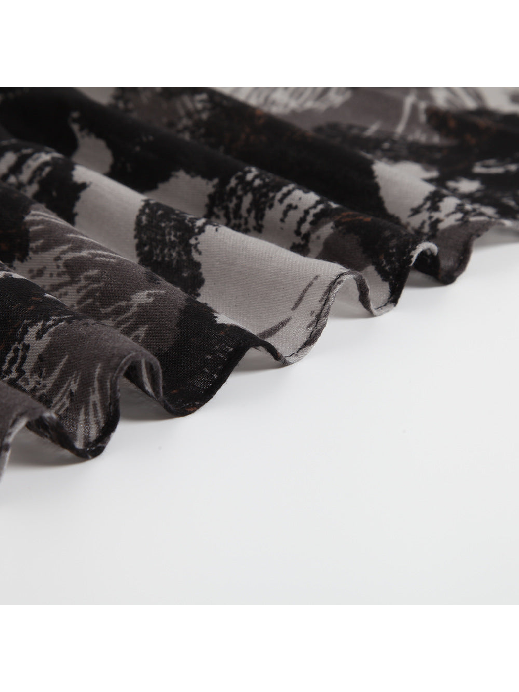 Close-up of the scarf's thin draped edge and abstract print