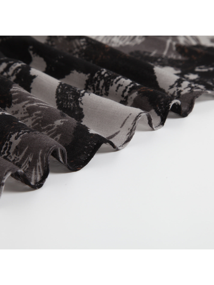 Close-up of the scarf's thin draped edge and abstract print