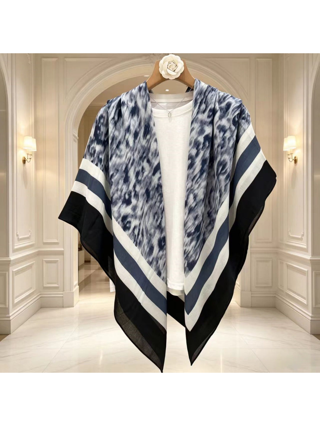 Blue-gray, black and white scarf draped open over a white top