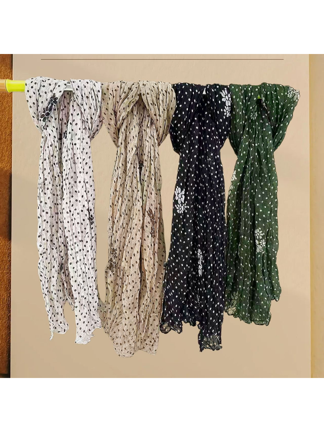 Ivory, beige, black and green polka-dot scarves displayed together