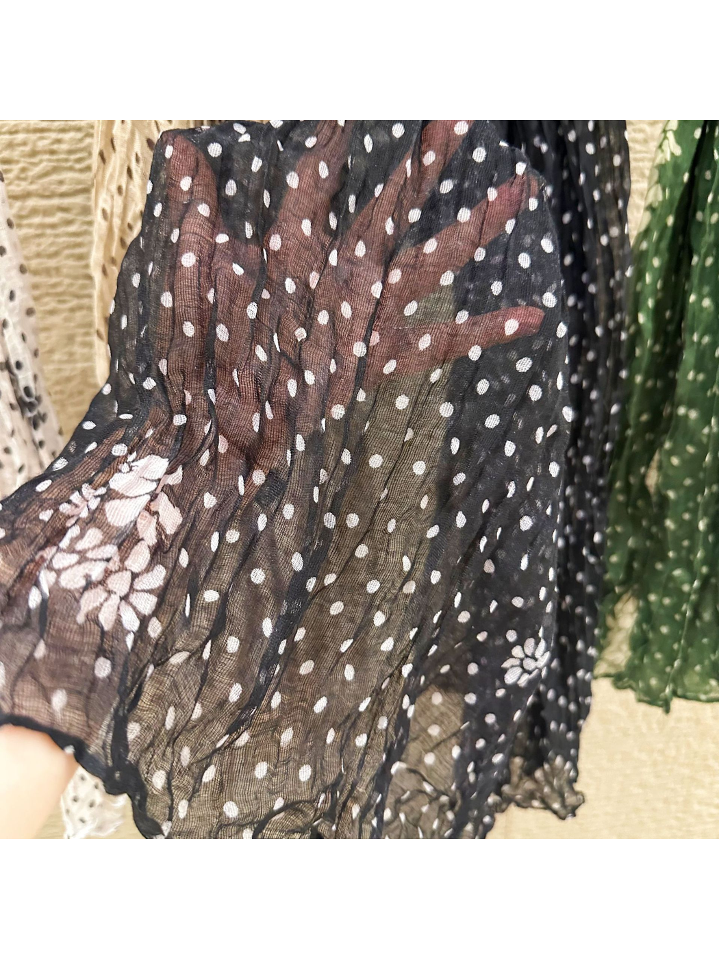 Close-up of the black scarf's white polka dots, floral accents and sheer weave
