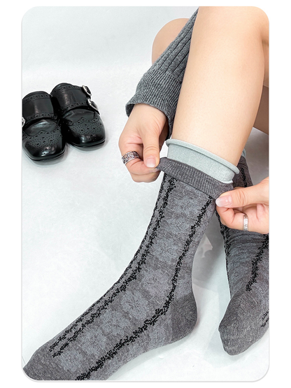 Gray floral crew socks shown with the rolled cuffs extended