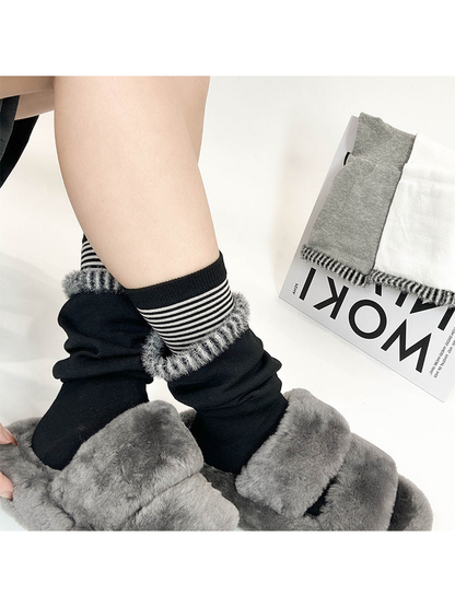 Black layered crew socks worn with gray plush slippers